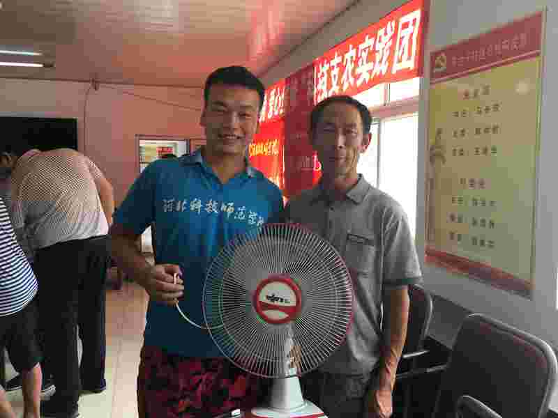 陈台子拿到修好的电扇的满脸笑容的村民2